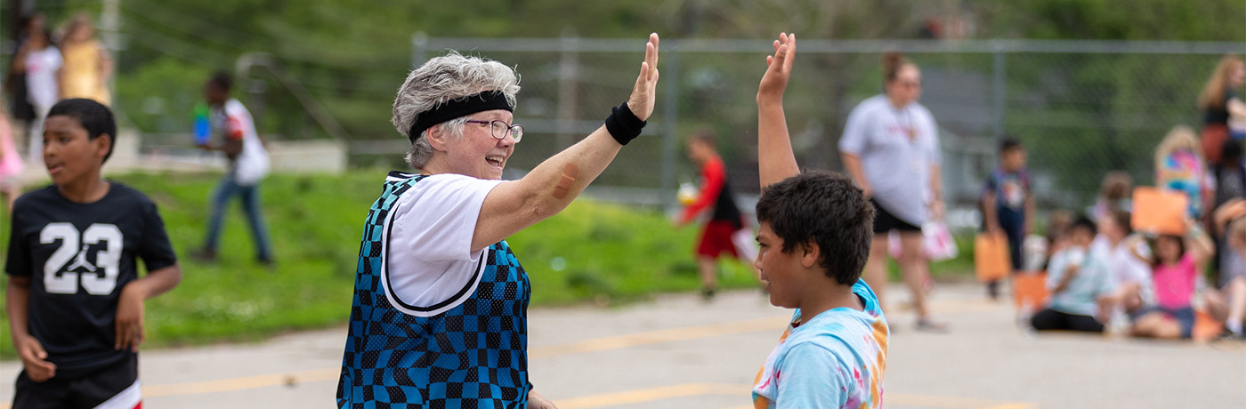 student high fiving teacher