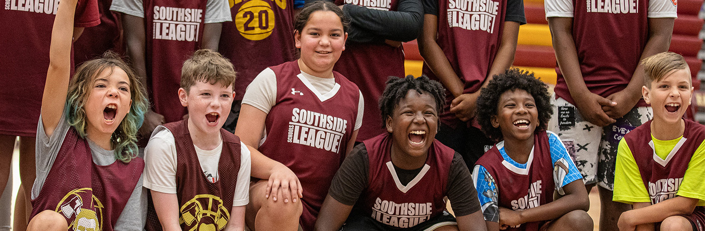 student basketball platers posing with trophy